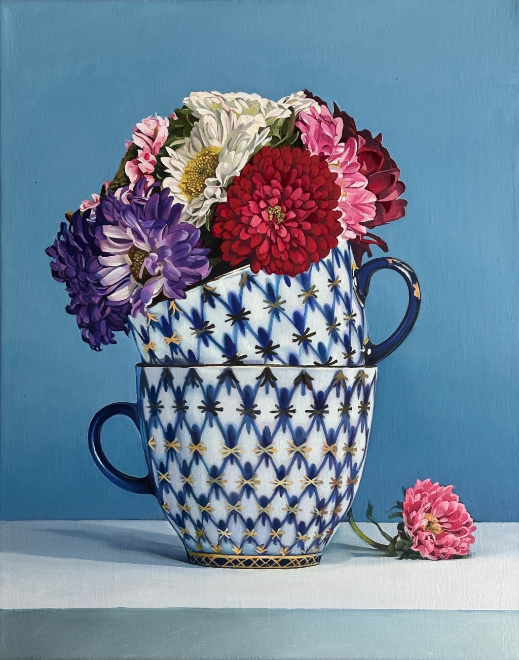 Oil painting of asters in two stacked blue-and-white porcelain teacups against a blue background